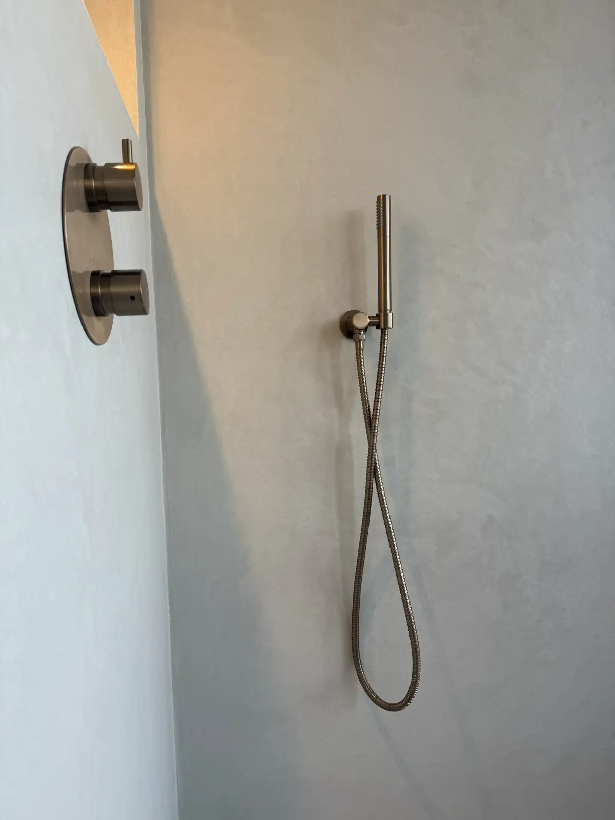 Microcement douche met glazen scherm naadloze wanden en vloer in lichtgrijs