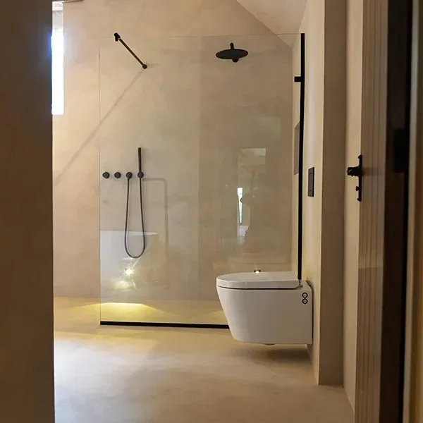 Microcement douchekoer — naadloze vloer en wanden in beige betonlook, inloopdouche