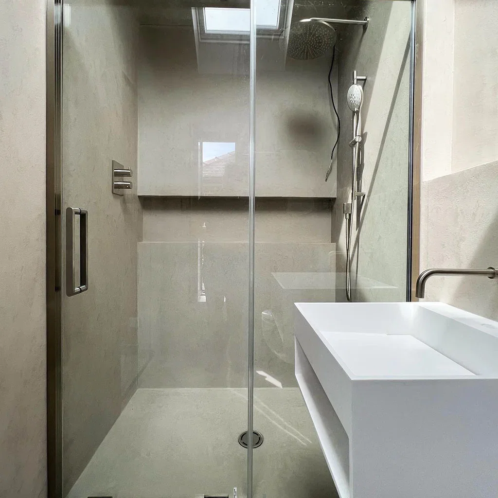 Microcement douchecabine met glazen deur — volledig waterdicht