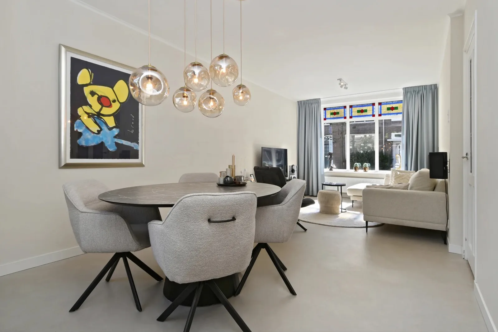 Warme woonkamer met naadloze gietvloer en salontafel — microcement of lavasteen in creme tint